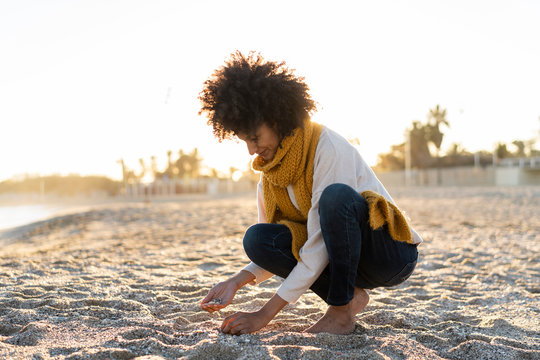 Woman collecting seashells on the beach