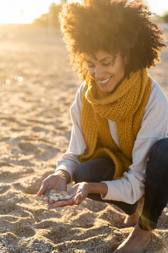 Woman collecting seashells on the beach