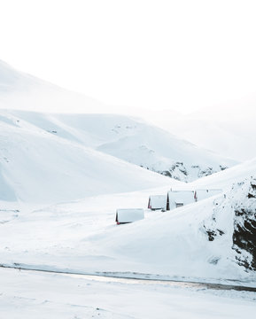 Houses next to snowy mountains 