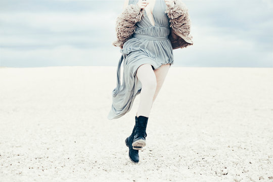 Fashionable woman running down sand dune