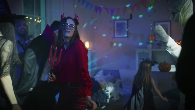 Halloween Costume Party: Group of Monsters Dancing in Decorated Room with Disco Ball Lights. Brain Dead Zombie, Vampire Dracula, Mummy, Beautiful Witch, She Devil, Death, Little Bloody Bride