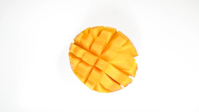 Above view of open orange mango rotaing round 360 degrees against white background