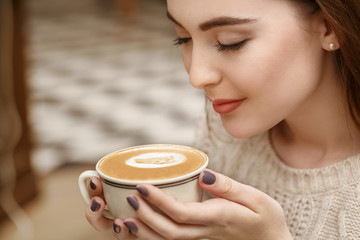 Loving the smell. Closeup shot of a gorgeous young woman smelling her coffee smiling cheerfully