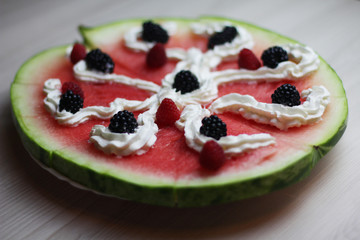 Tasty watermelon pizza with fresh berries and cream