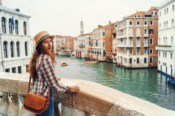 Fototapeta na wymiar Woman in the Venice, standing on the bridge over the grand canal while on sightseeing in a foreign city. Discovery the Venice adventure.