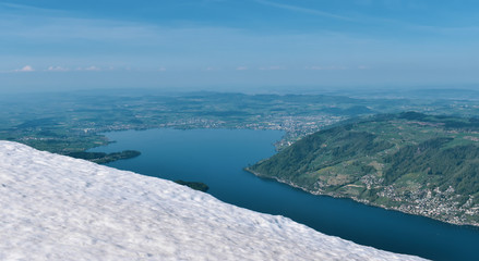 Beautiful spring panoramic view of snow-capped mountains in the Swiss Alps. Lake Zug in the background