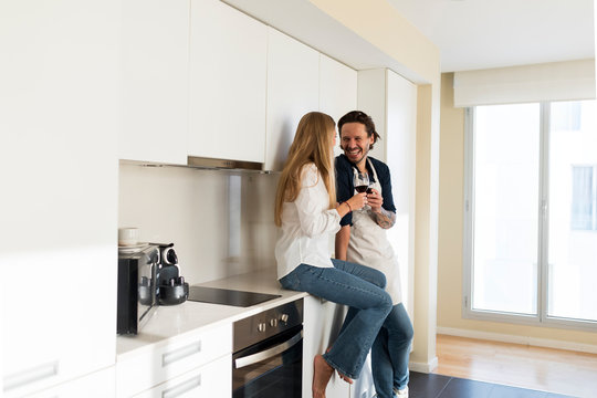 Affectionate couple drinking red wine in the kitchen