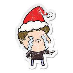 distressed sticker cartoon of a man crying wearing santa hat