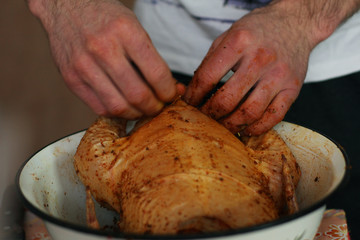 The young guy is cooking big chicken