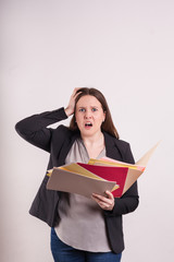 Buisness professional woman in suit frustrated hand on head looking at camera holding scattered papers and file folders