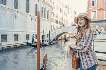 Fototapeta na wymiar Woman waiting for gondolas near canal in Venice