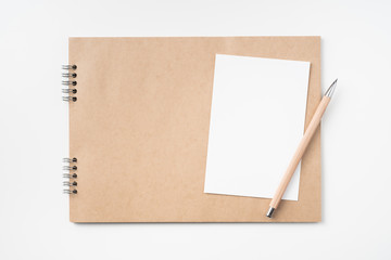 kraft notebook, photo frame and pen on white