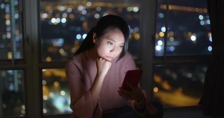 Woman feeling tired and look at the cellphone at home