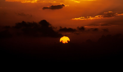 colorful sunset in the sea behind clouds