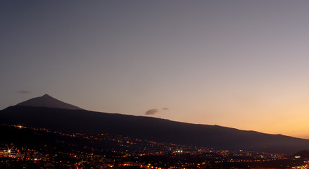 spectacular sunset near the mountain with night city