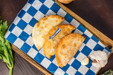 Argentinian empanadas with flag on a dark wooden background