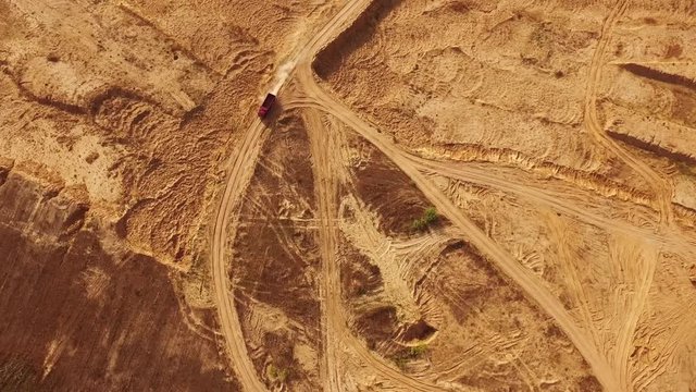 View of the large red truck in desert moving on a sandy track. Desert trip.