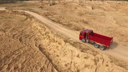 Close-up view the red truck moving on desert or dune track. Beautiful view from above.