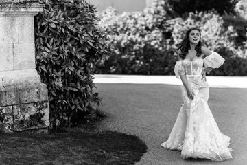 Black and white photo of an awesome bride who smiles and poses in luxury white dress on her happy wedding day