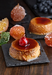 homemade egg custard with caramelized fruits on black stone tray