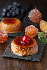 homemade egg custard with caramelized fruits on black stone tray