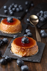 two homemade egg custards with cranberries on a black stone tray