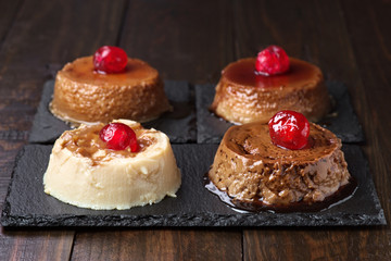 homemade puddings various flavors on black stone tray