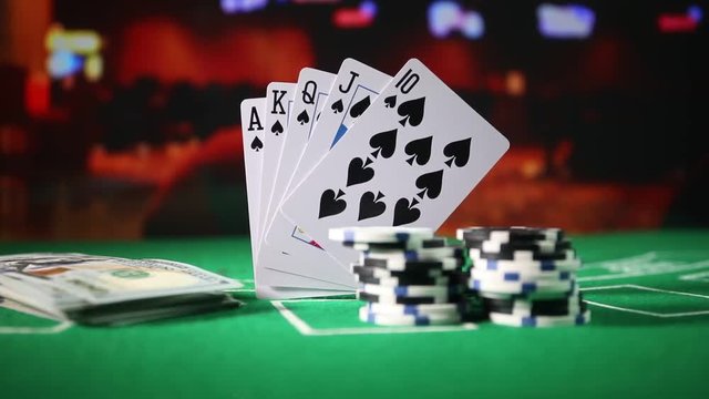 Cards and chips on green felt casino table. Abstract background with copy space. Gambling, poker, casino and cards games theme. Casino elements on green. Selective focus