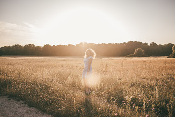 Frau genießt den Sommer und tanzt durch ein Feld