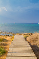 Fototapeta na wymiar Wooden deck or walkway to sea. Sea beach relax, outdoor travel. Copy space background - Image