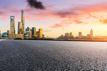 Empty asphalt road through Shanghai business district at sunset