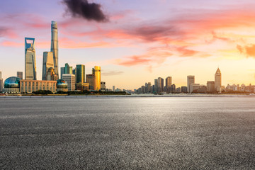 Empty asphalt road through Shanghai business district at sunset