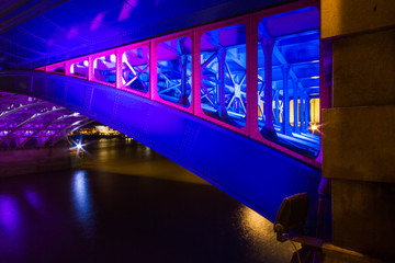 A night long exposure of a bridge metal arch with blue and pink neon color