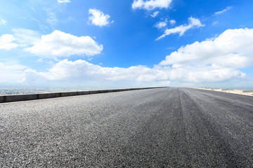 Asphalt highway passing above modern city