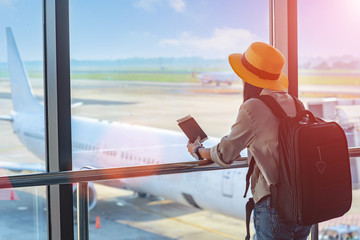 woman traveller holding passport waiting in transit area of airport, stand by for the next schedule...