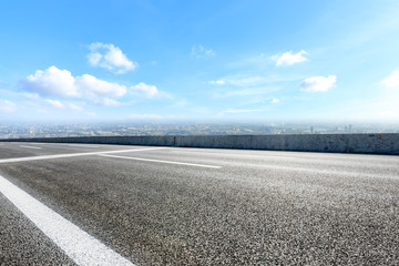 Asphalt highway passing above modern city