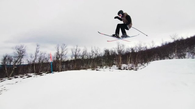 Skier doing a jump on a medium big jump at the ski resort.