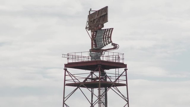 Close up zoom of a small radar tower checking civilian air traffic.
