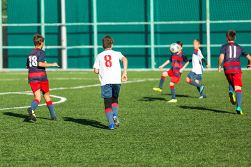 Football training soccer for kids. Boy runs kicks dribbles soccer balls. Young footballers dribble and kick football ball in game. Training, active lifestyle, sport, children activity concept 