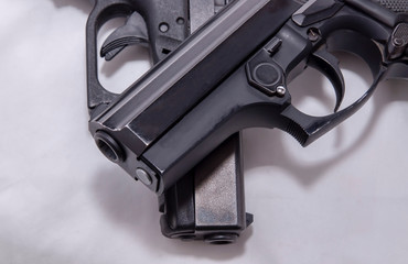 Two black pistols, a 9mm and a 40 caliber, one on top of the other on a white background