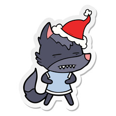 sticker cartoon of a wolf showing teeth wearing santa hat