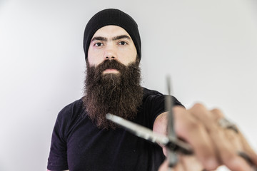 barber with long beard using scissors