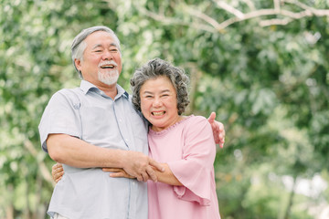 Happy senior couple holding each other in park