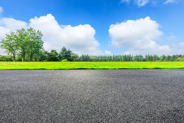 Empty asphalt pavement and green forest landscape in summer season