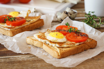 Sandwich with fried egg, tomato and fried cheese.