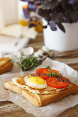 Sandwich with fried egg, tomato and fried cheese.