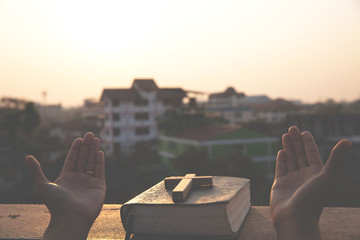 Women pray to God with the Bible and the cross  with morning sunrise. Woman Pray for god blessing...