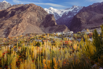 Landscape autumn  in Hunza valley. Beautiful mountainous scenery with colorful foliage, Baltit fort and snow capped Ultar Sar mountain in Karakoram range. Gilgit Baltistan, Pakistan.