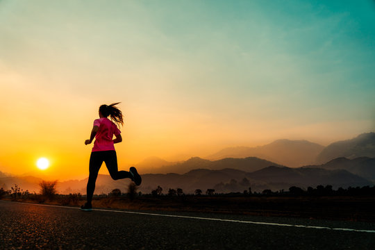 Young woman enjoys running outside with beautiful summer evening in the countryside.