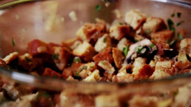 Beautiful up close shot of stuffing ingredients being stirred together in a glass bowl. Great detail and color in 4K. Stuffing ingredients are not cooked yet.